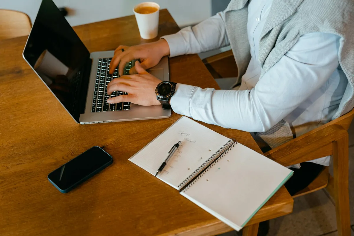 A solopreneur at a desk with a notebook and laptop, sketching a weekend plan for testing a business idea before building anything