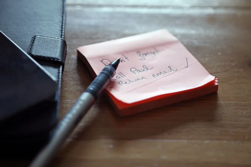 A handwritten checklist on a sticky note with a pen beside a notebook, standing in for a structured list of criteria instead of a feeling