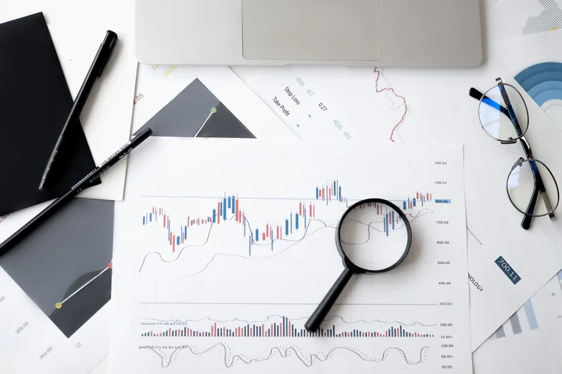 Documents and magnifying glass on a desk representing careful analysis of survey response data to find patterns