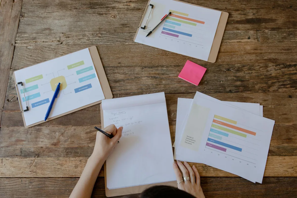 Business analysis documents and charts on a desk — the foundation of structured idea evaluation