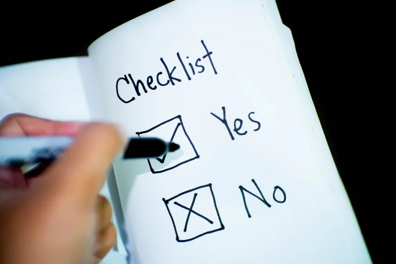 A checklist notebook with a marked Yes box, representing the go, wait, or kill decision at the end of validating a business idea