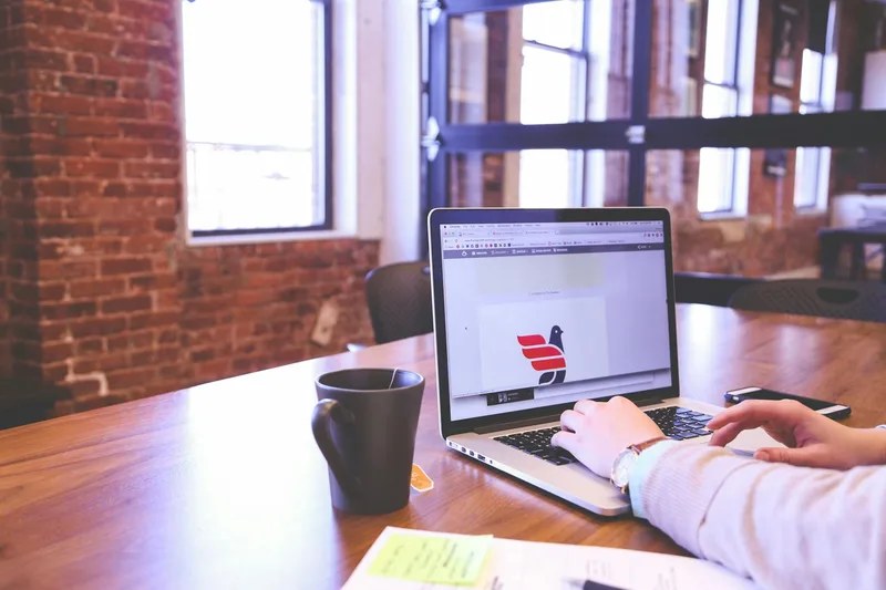 A person setting up a minimal landing page on a laptop for an idea demand test